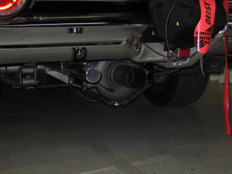 1991 Ford LTD Crown Victoria - Underside view showing a large exhaust outlet, rear axle and a red DEIST drag parachute pack mounted beneath a car.