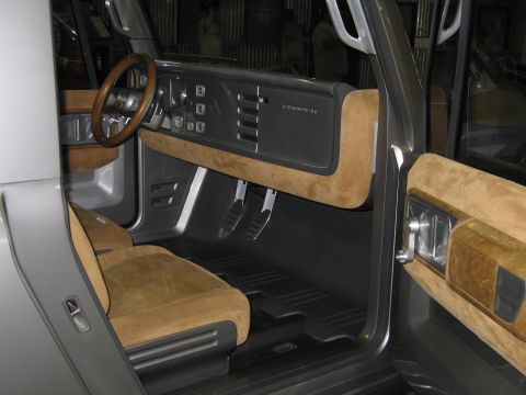 1991 Ford LTD Crown Victoria - Interior of a silver concept vehicle showing tan suede bucket seats, a wood-rimmed steering wheel and a dark metallic dash.