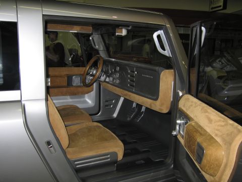 1991 Ford LTD Crown Victoria - Open-door view into a silver concept SUV cabin with tan suede seats, wood-trimmed dash and a wood-rimmed steering wheel.