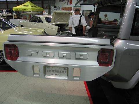 1991 Ford LTD Crown Victoria - Silver custom vehicle's brushed FORD decklid with round taillights and a NAIAS BRONCO GIDDYUP license plate in an indoor display.