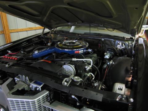 1991 Ford LTD Crown Victoria - Restored engine compartment under a raised hood with blue air cleaner and braided hoses, chrome grille visible at front.