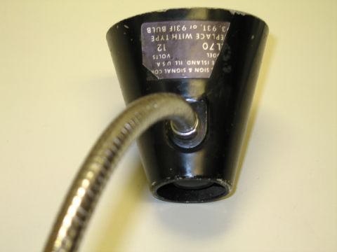 1991 Ford LTD Crown Victoria - Close-up of the black bell-shaped lamp shade base showing the bulb socket and embossed manufacturer label reading model L70, 12 volts.