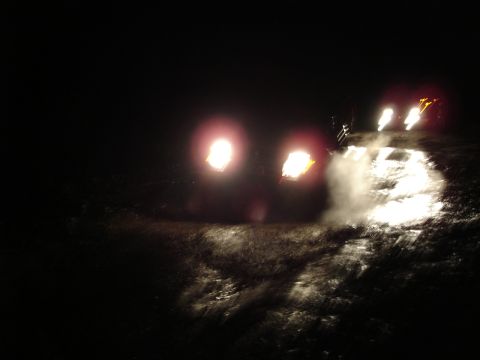 1989 Ford Bronco - Headlights pierce the darkness, reflecting off a wet surface.