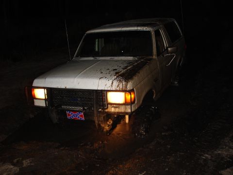 1989 Ford Bronco - This 1987 Ford Bronco is stuck in the mud at night, with a rebel flag attached to the front grille.