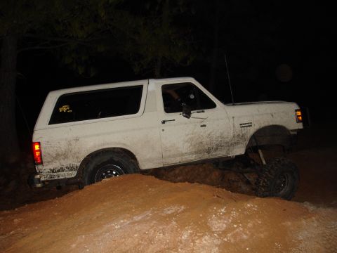 1989 Ford Bronco - White 1989 Ford Bronco navigates an off-road trail in the dark.