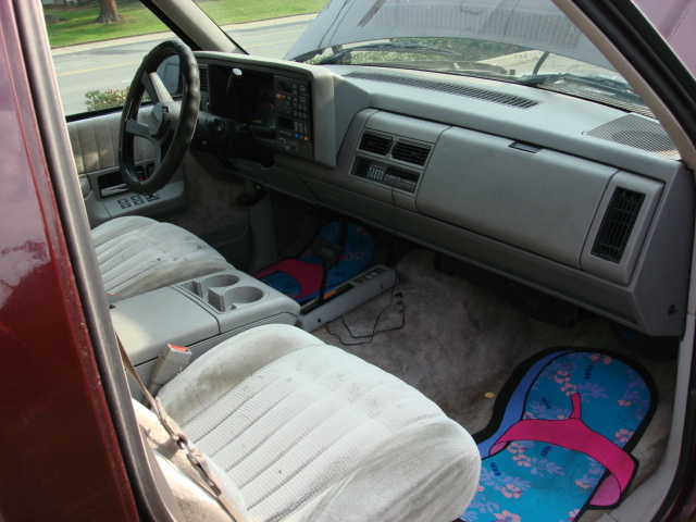 Gray cloth truck interior with bench seat, dash, and floor mats