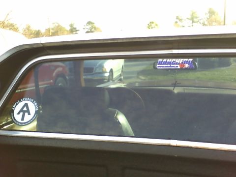 1979 Ford Ranchero - Rear window interior view with stickers, reflecting other vehicles outside.