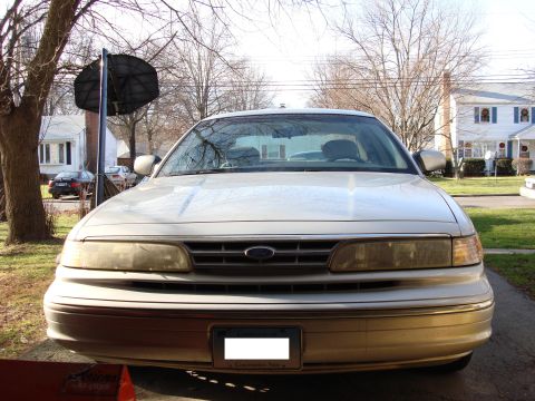 2003 Ford Crown Victoria - A gold Ford Crown Victoria is parked in a driveway with a basketball hoop nearby.