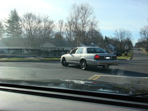 2003 Ford Crown Victoria - Silver 2003 Ford Crown Victoria sedan seen from another vehicle's perspective.