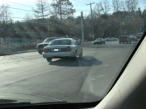 2003 Ford Crown Victoria - A silver 2003 Ford Crown Victoria is seen driving on a road with other vehicles.