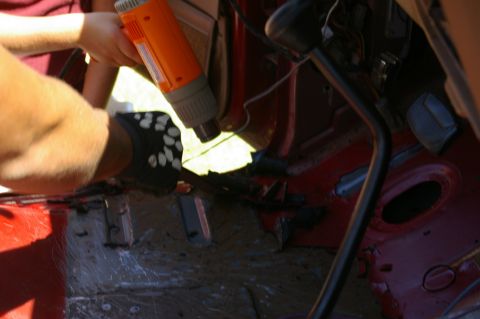 1986 Ford Bronco - A heat gun is used on the interior floor of a vehicle, likely during a restoration or modification process.