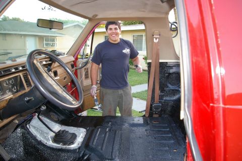 1986 Ford Bronco - Man applies black bedliner coating to the interior floor of a 1986 Ford Bronco.