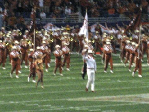1986 Ford Bronco - A marching band performs on a football field during a game or event.