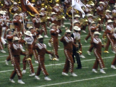 1986 Ford Bronco - A marching band performs on a football field, with members in distinctive uniforms and hats.