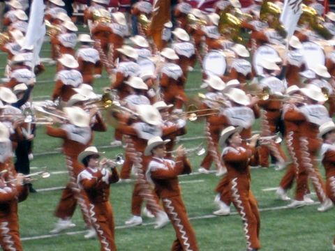 1986 Ford Bronco - A marching band performs on a football field, playing brass instruments and wearing distinctive uniforms.