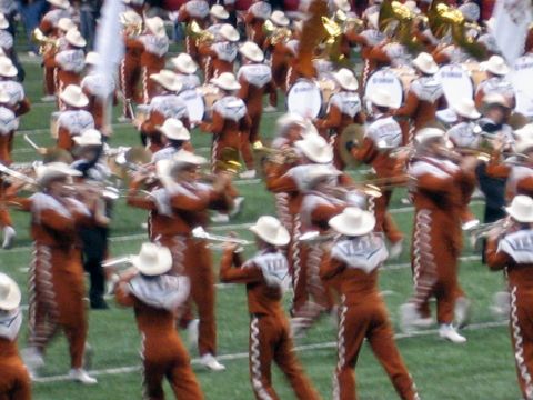1986 Ford Bronco - A large group of musicians in uniform are performing on a grassy field, likely during a sporting event.