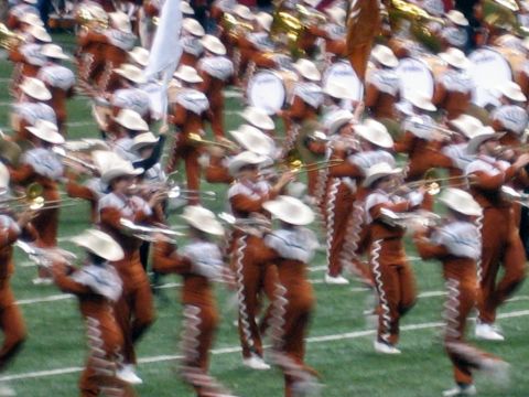 1986 Ford Bronco - A marching band performs on a football field, with members wearing distinctive uniforms and cowboy hats.
