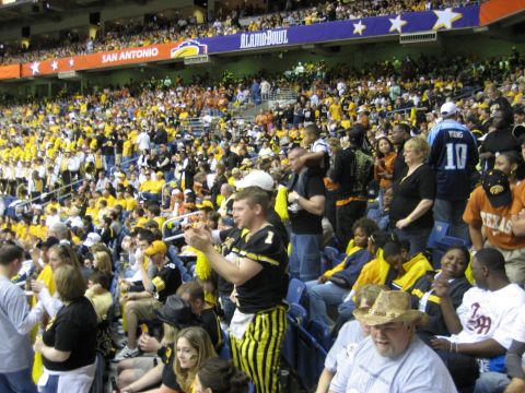 1986 Ford Bronco - A crowded stadium during the Alamo Bowl, with fans in yellow and black attire filling the stands.