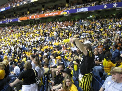 1986 Ford Bronco - Fans fill the stadium seats during the Alamo Bowl, with many sporting team colors.