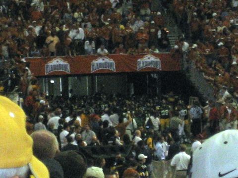 1986 Ford Bronco - A large crowd fills a stadium, with banners indicating the 'Alamo Bowl' event.