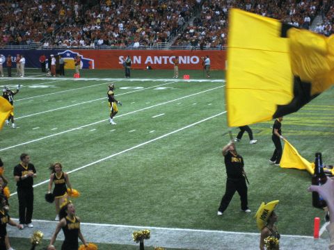 1986 Ford Bronco - A football game is underway with players and cheerleaders on the field, and a large yellow flag being waved.