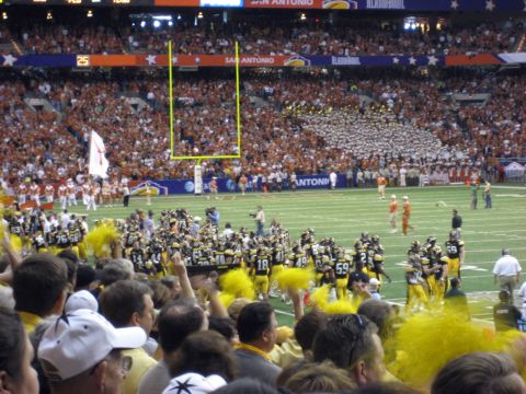 1986 Ford Bronco - A football game is underway with players on the field and spectators in the stands.