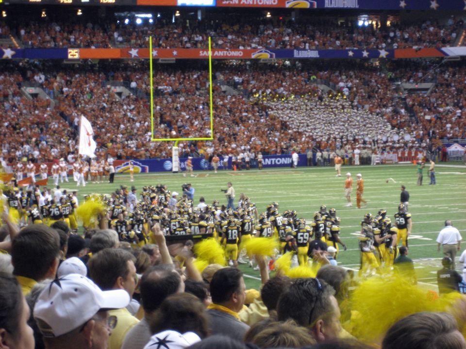 Football game with goalposts and cheering crowd