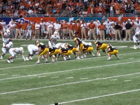 1986 Ford Bronco - Players line up for a play during an American football game in a stadium filled with spectators.
