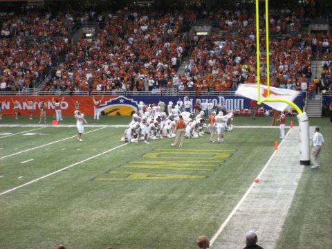 1986 Ford Bronco - A football game is underway with players on the field and spectators filling the stadium.
