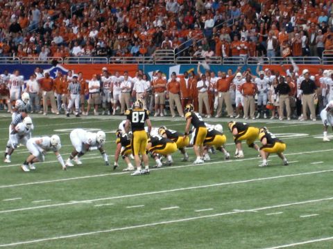 1986 Ford Bronco - A football game is underway with players on the field and a crowd in the stands.
