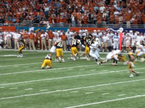 1986 Ford Bronco - A football game is in progress with players on the field and spectators in the stands.