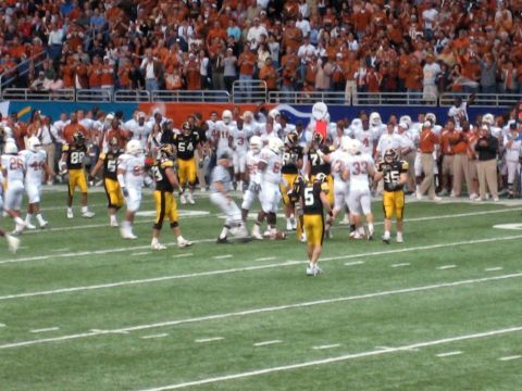 1986 Ford Bronco - Players in uniform are on a football field during a game, with a large crowd watching.