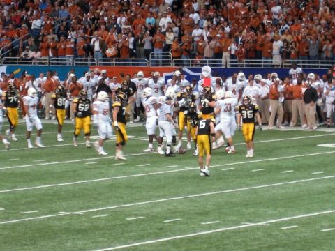 1986 Ford Bronco - A football game is underway with players on the field and a crowd in the stands.