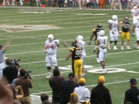 1986 Ford Bronco - Players in uniform on a football field during a game, with spectators in the background.