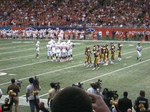 1986 Ford Bronco - A football game is underway with players on the field and a crowd in the stands.