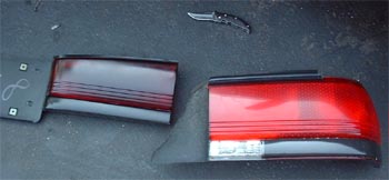 1997 Ford Crown Victoria - A pair of car tail lights are laid out on a dark surface, with a utility knife nearby.