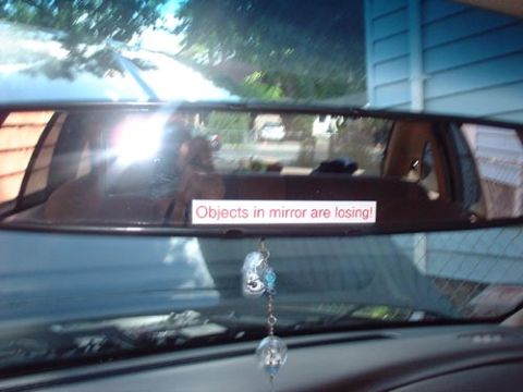 1997 Ford Crown Victoria - A sticker on the rearview mirror reads "Objects in mirror are losing!".