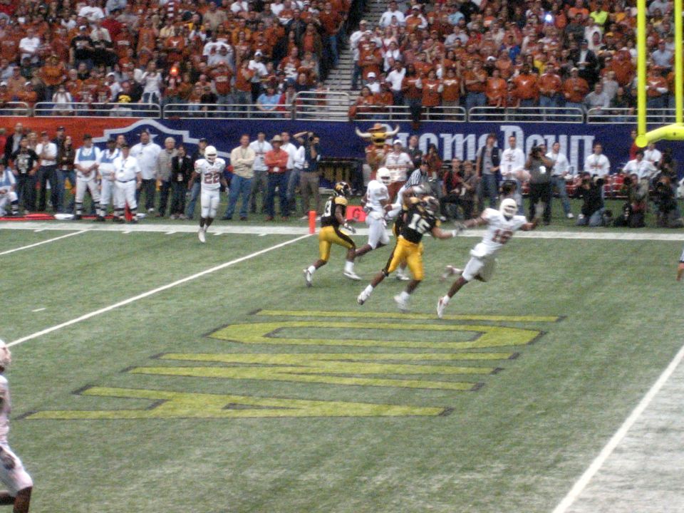 football players on field during game, crowd in stands