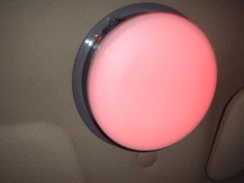1997 Ford Crown Victoria - The interior dome light is illuminated with a soft red glow, casting light onto the car's headliner.