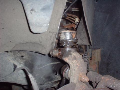 1997 Ford Crown Victoria - Detail of a vehicle's suspension system, showing a worn ball joint and surrounding components.