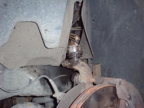1997 Ford Crown Victoria - Close-up view of a worn front suspension ball joint, showing signs of rust and grease accumulation.