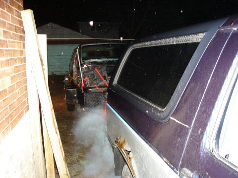 1990 Ford Bronco - Two vehicles are visible, one is a purple Ford Bronco with visible rust and damage.