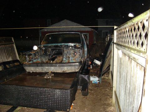 1990 Ford Bronco - A stripped-down truck chassis is loaded onto a trailer at night.
