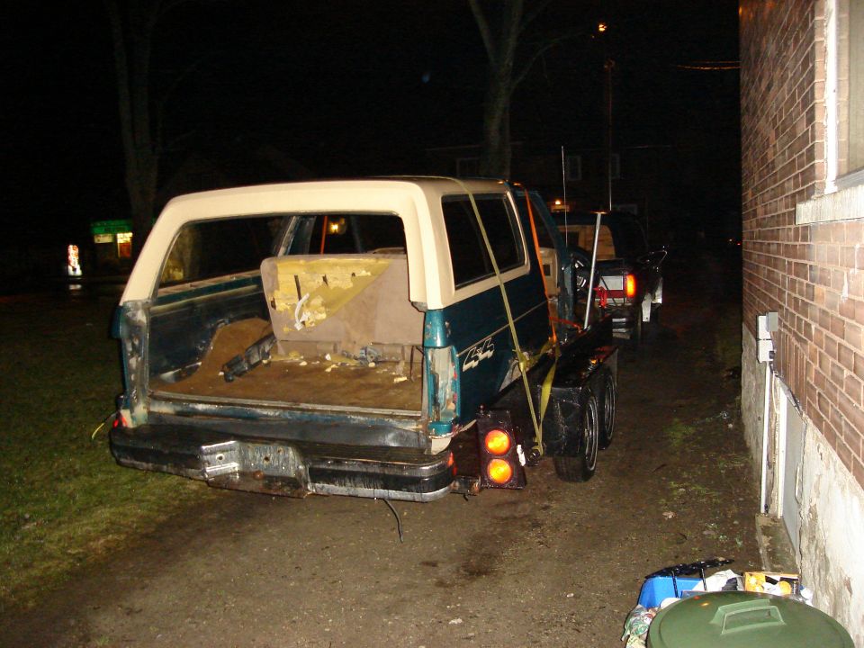 Teal and cream SUV on trailer, rear view. 1990 Ford Bronco