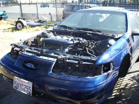 1992 Ford Taurus - Blue 1992 Ford Taurus with hood open, revealing the engine bay. License plate is visible.