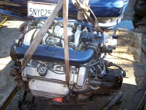 1992 Ford Taurus - Engine with "24 VALVE DOHC" text, hoisted for installation or removal.