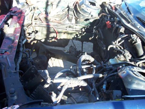1992 Ford Taurus - The engine bay is exposed, revealing the car's internal components and wiring after engine removal.