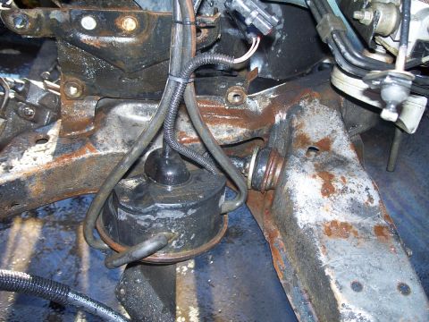 1992 Ford Taurus - Close-up view of a vehicle's engine mount and rusty chassis components.