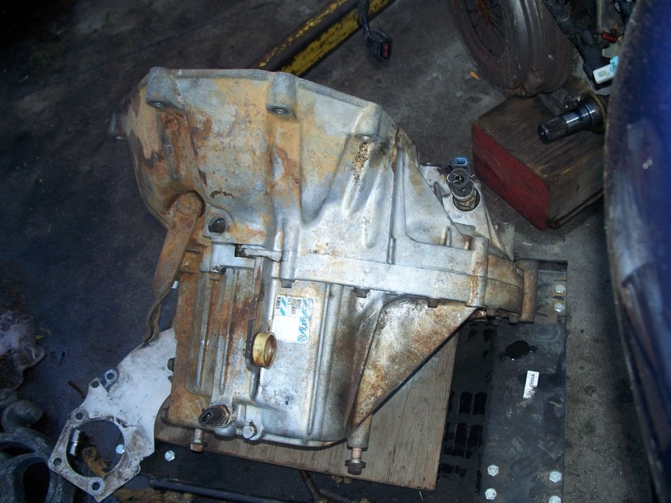 Automatic transmission with a sticker on its side, resting on a wooden surface