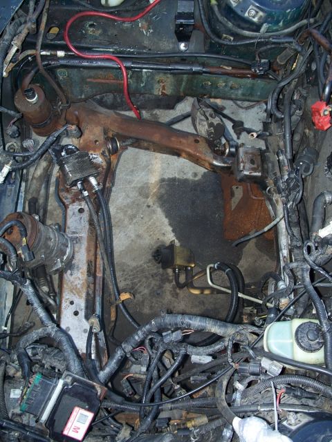 1992 Ford Taurus - Exposed engine bay shows a complex network of wiring and hoses, with visible suspension parts.